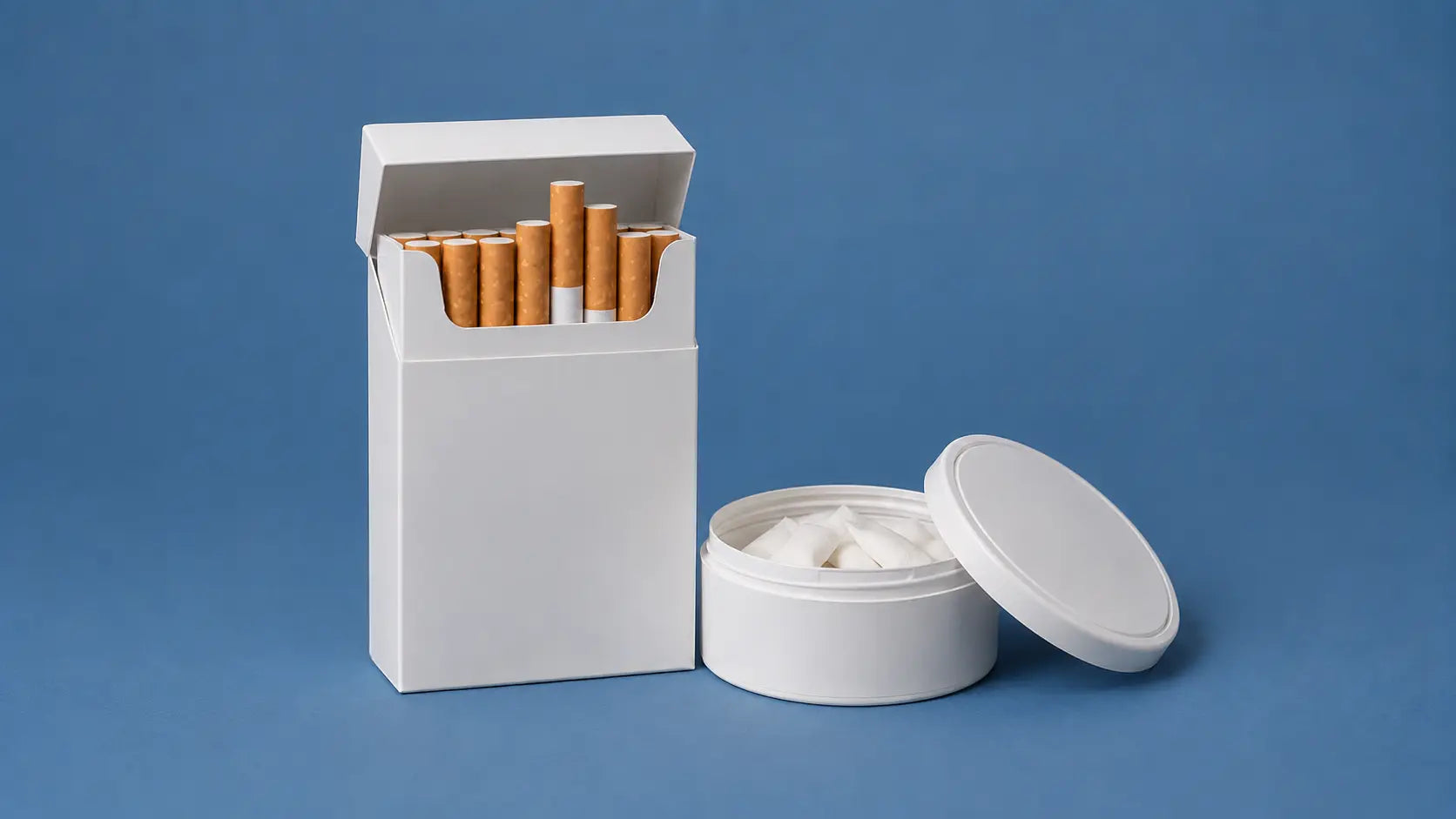 Plain white cigarette pack and white nicotine pouch container on a solid blue background, showing a smoke-free alternative compared with cigarettes.